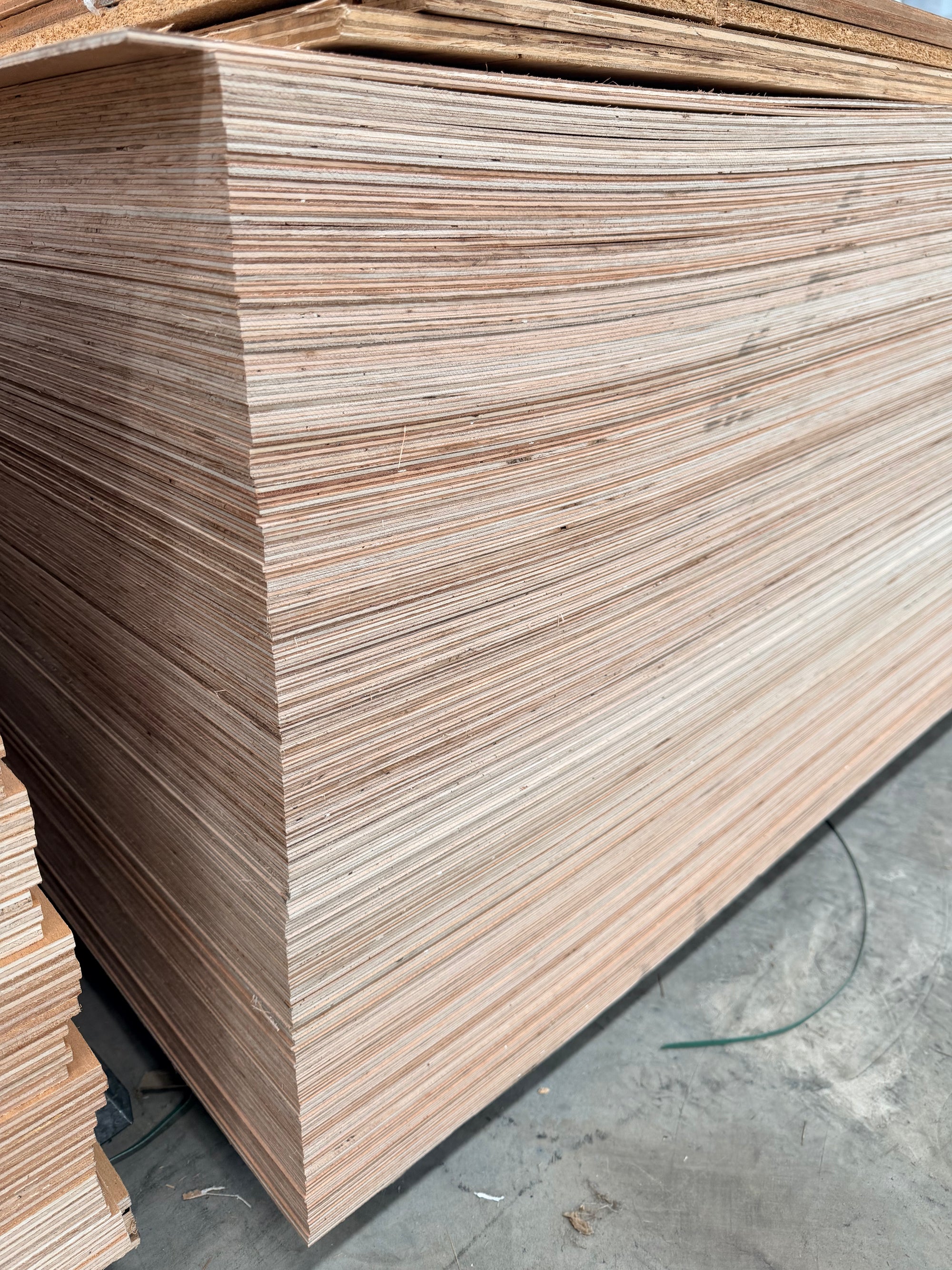 Large stack of plywood sheets in a warehouse setting