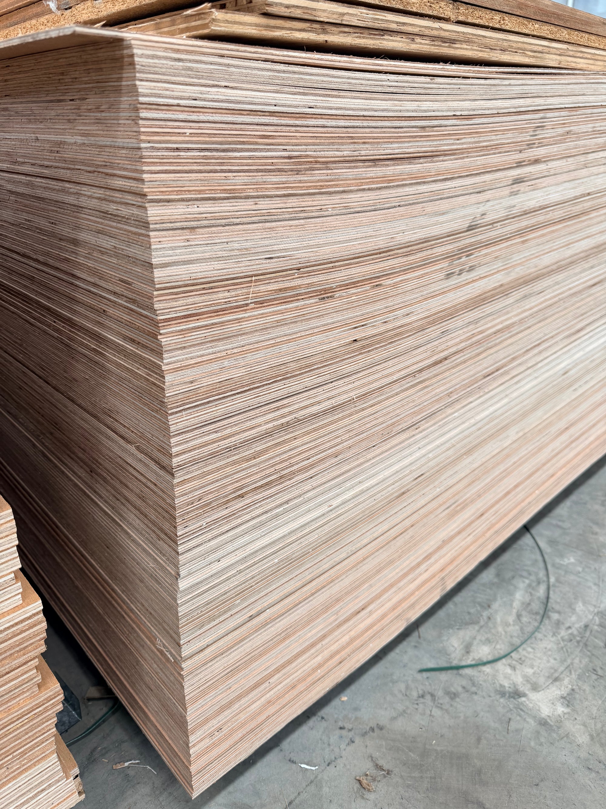 Large stack of plywood sheets in a warehouse for construction or woodworking projects