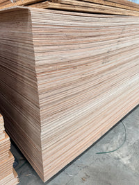 Large stack of plywood sheets in a warehouse for construction or woodworking projects